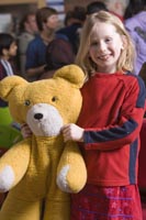 Colour photograph of the upper profile of Riona Shergold holding a teddy bear.