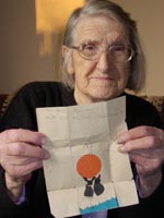 Colour photograph of the upper profile of Ruby Sampson holding a card made by her son.