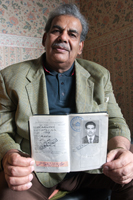 Colour photograph of the upper profile of Saleh Muthana holding his first passport.