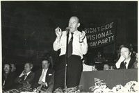 Black and white photograph of George Caborn speaking at a rally in the City Hall.