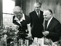 Black and white photograph of Alice Ingham receiving a gift from staff at Bachelors Peas.