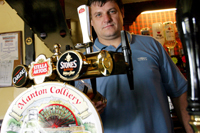 Colour photograph of John Lesley behind the bar at The Rock Public House.