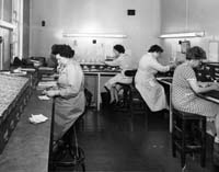 Black and white photograph of workers in the Wigfalls record office, 1962.