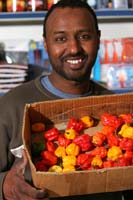 Colour photograph of Mohammed Mohammed holding a box of chillies.