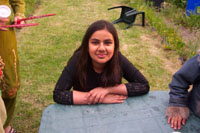 Colour photograph of Rabia Khan sitting in her garden.