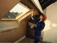 Colour photograph of Annie Blindell plastering round a window.