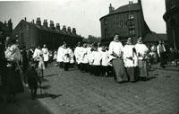 Black and white photograph of a Whit Walk procession.