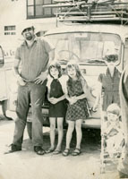 Black and white photograph of the Spinks family next to their camper van.