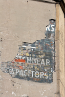 Colour photograph of an old fashioned advert painted on to a wall 