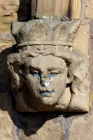 Colour photograph of a carved stone head on the exterior of the chapel at Burngreave Cemetery