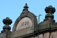 Colour photograph of a stone semicircle with the date 1864 carved on it at the front of Burngreave Vestry Hall