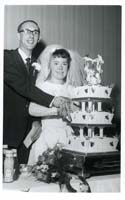 Black and white photograph of Janice and Tony Gear with their wedding cake, 1966.