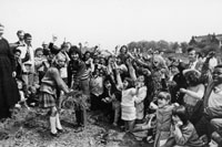 Black and white photograph of  children and adults digging the first sod for the new St Catherines Primary School