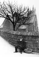 Black and white photograph of Christ Church with a man selling oranges seated outside