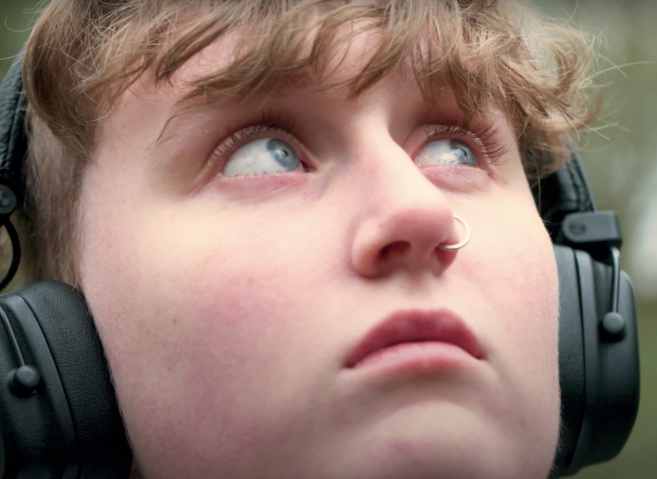 Close-up of a face of a young person wearing headphones.