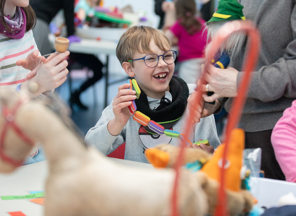 A child laughing while taking part in a schools workshop. 