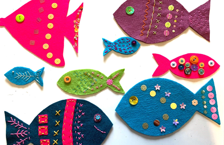 A collection of brightly coloured fish, made from recycled materials. 