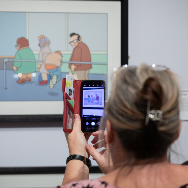 A person takes a picture of a colour painting on their phone