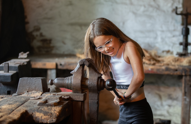 A young visitor tries a historic bench vice at Abbeydale Industrial Hamlet.