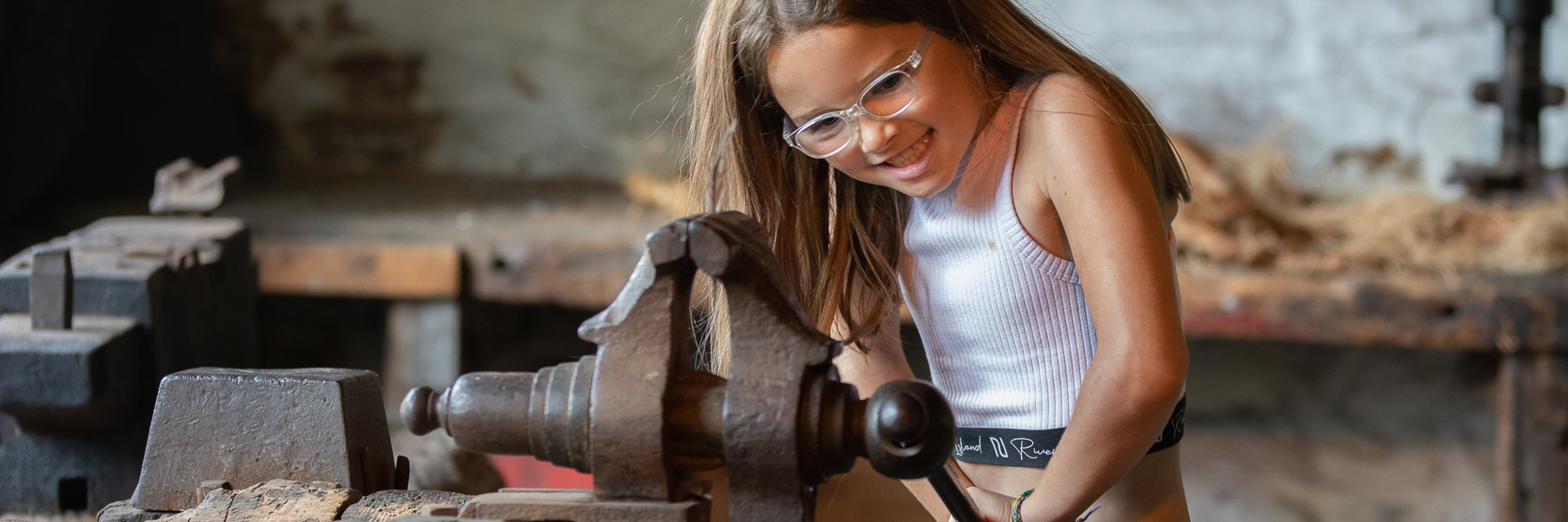 A young visitor tries a historic bench vice at Abbeydale Industrial Hamlet.