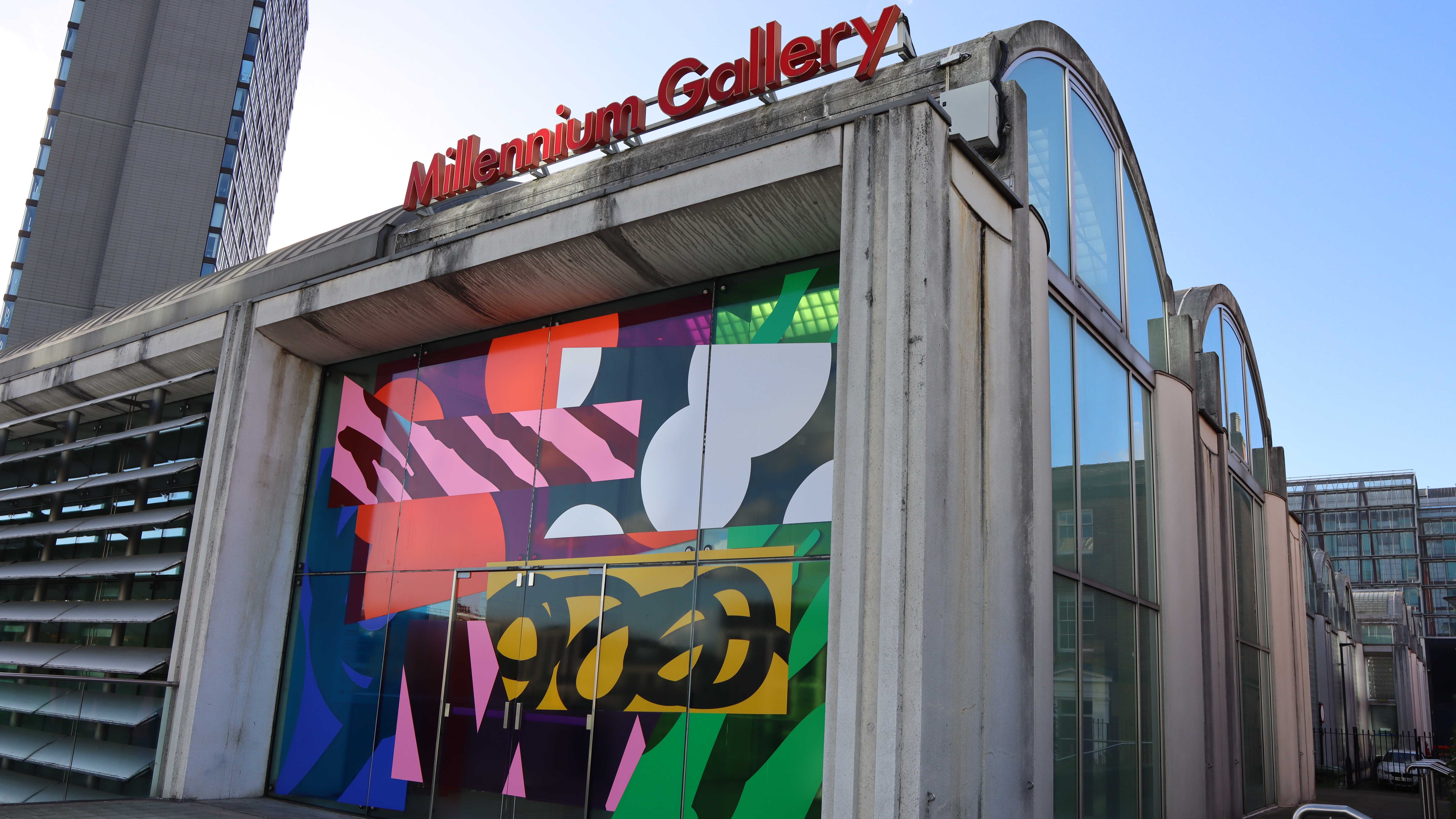 Exterior of Millennium Gallery featuring a bright, abstract design made from vinyl covering the window.