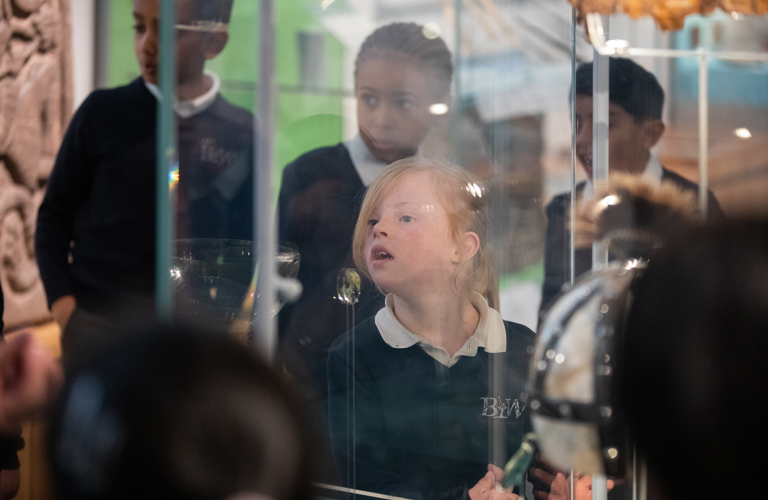 A primary school aged child, seen through a glass exhibition case.