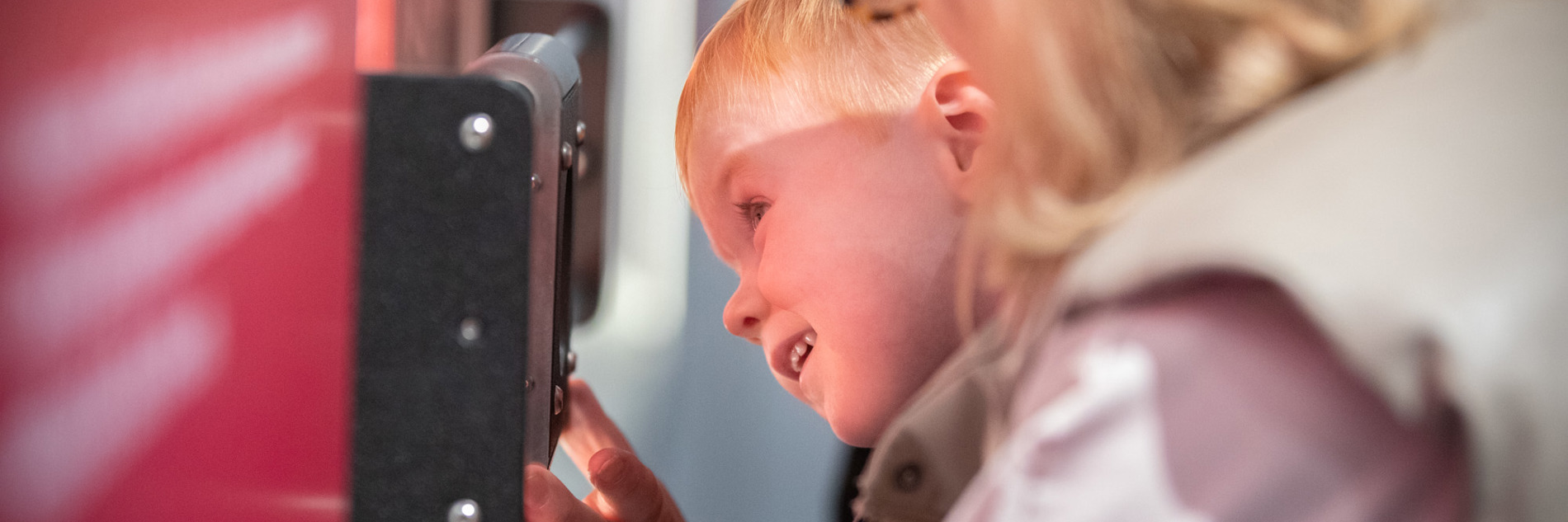 A child with an adult looking closely at a museum exhibit