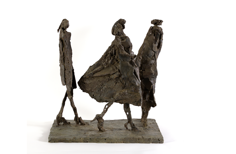 A photograph of a sculpture of three people caught in a walking motion. They are loosely sculpted in a brown medium