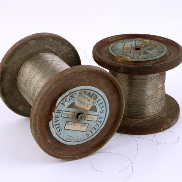 Two rusty bobbins of of stainless steel thread.