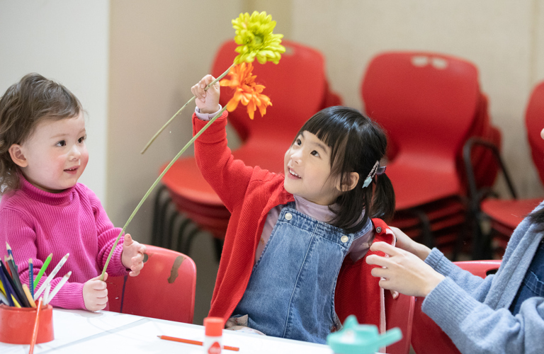 Children playing with flowers as part of a craft activity.