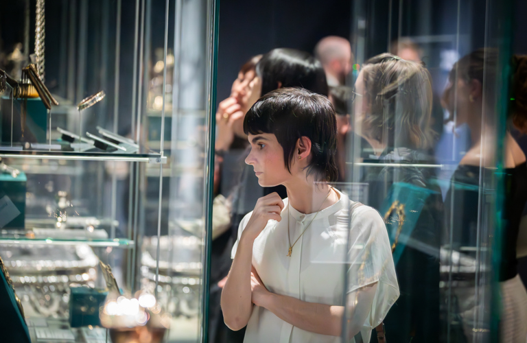 A photograph of a visitor looking at the display cabinets in Millennium Gallery.
