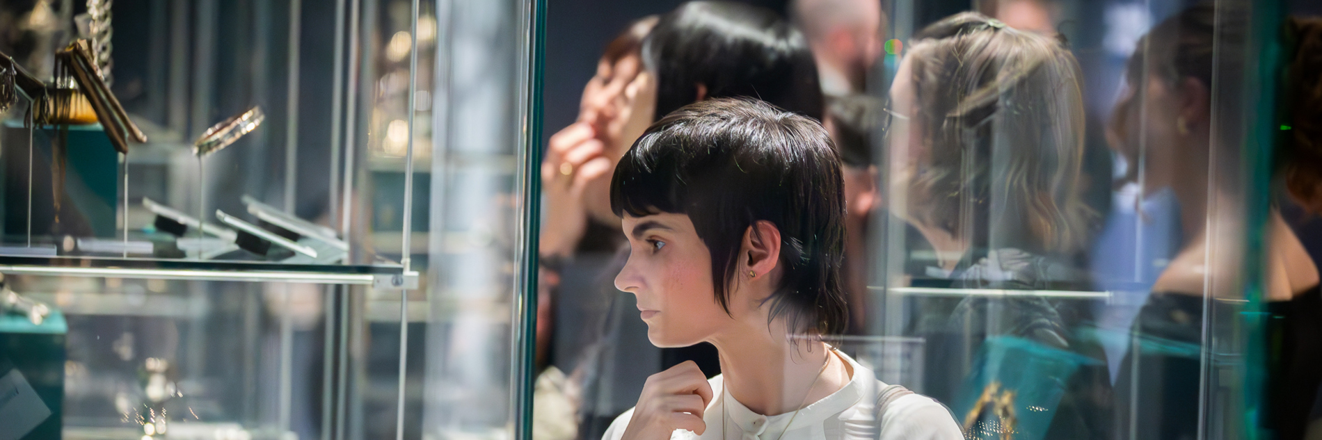 A photograph of a visitor looking at the display cabinets in Millennium Gallery.