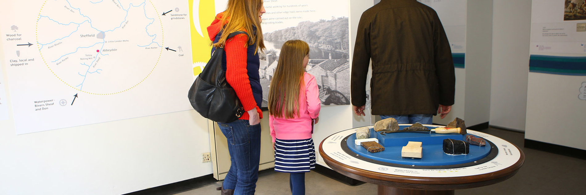 Two adults and a child viewing displays in the museum.