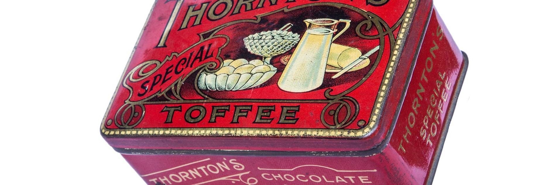 A red tin with the words Thornton's Special Toffee in gold. There is an illustration on the lid of a white jug of milk, a bowl of eggs and a plate of butter with a knife.