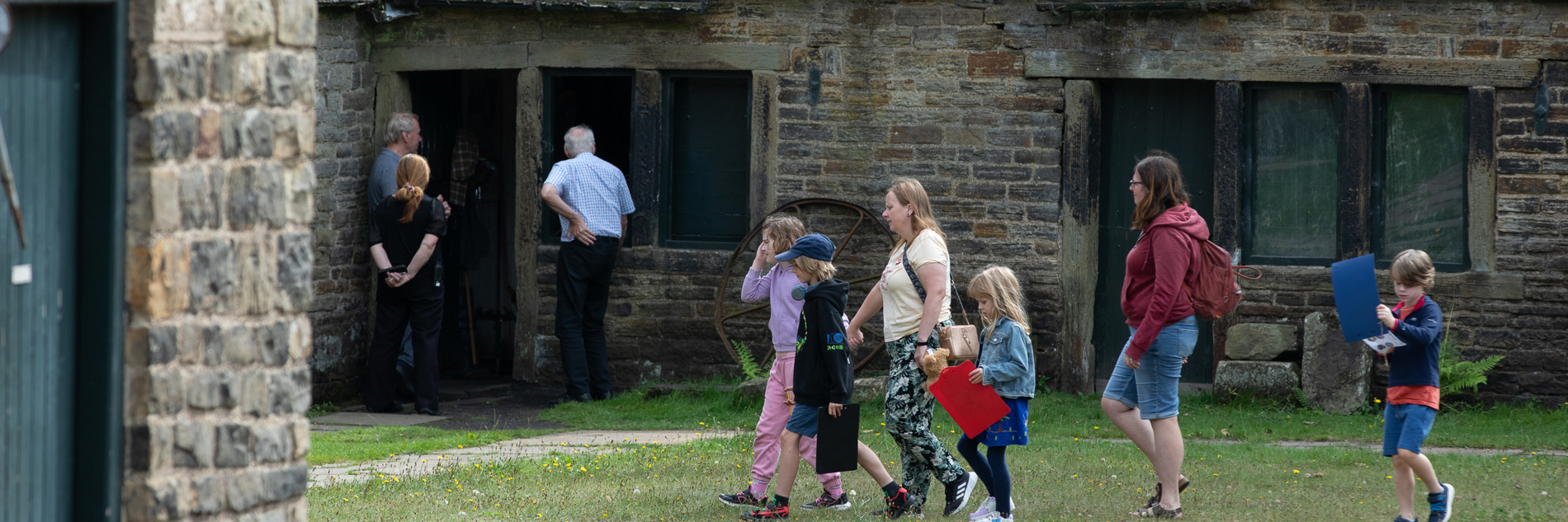 A group of children and adults walking in front of a building. 