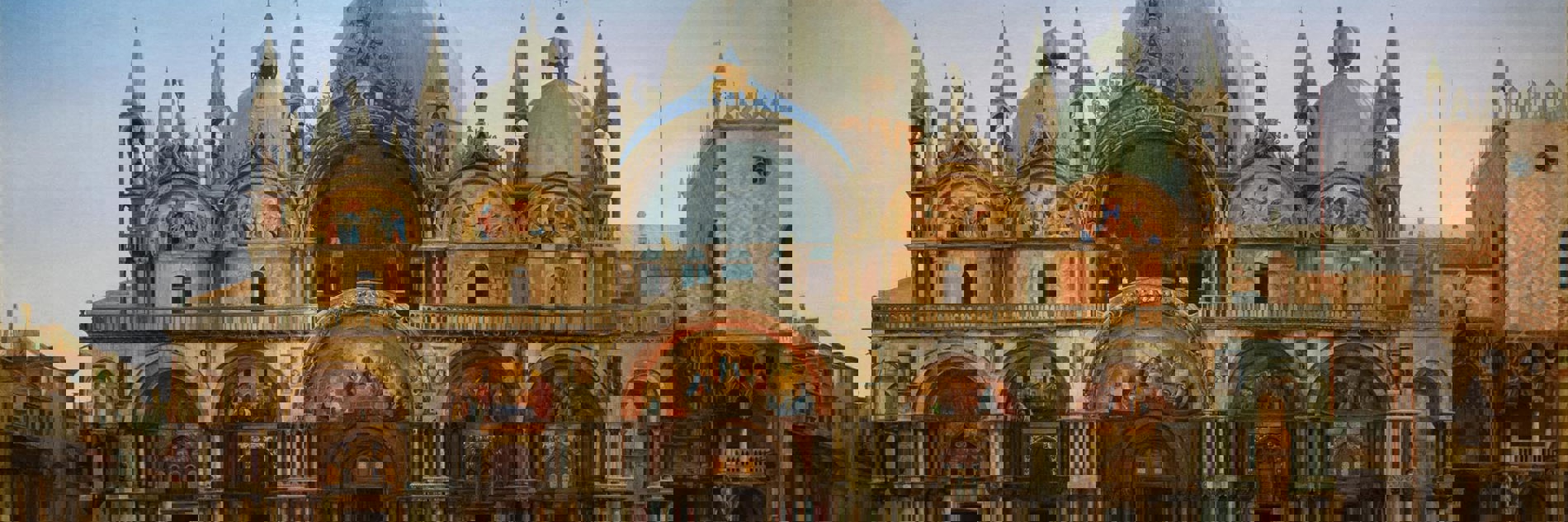 J.W.Bunney's painting Western Façade of the Basilica of San Marco, Venice. The basilica has many impressive golden arches and white domes, inspired by Islamic architecture. The square stretches out in front of, with only very few people depicted. The sky is blue at the top, but looks close to sunrise or sunset. 