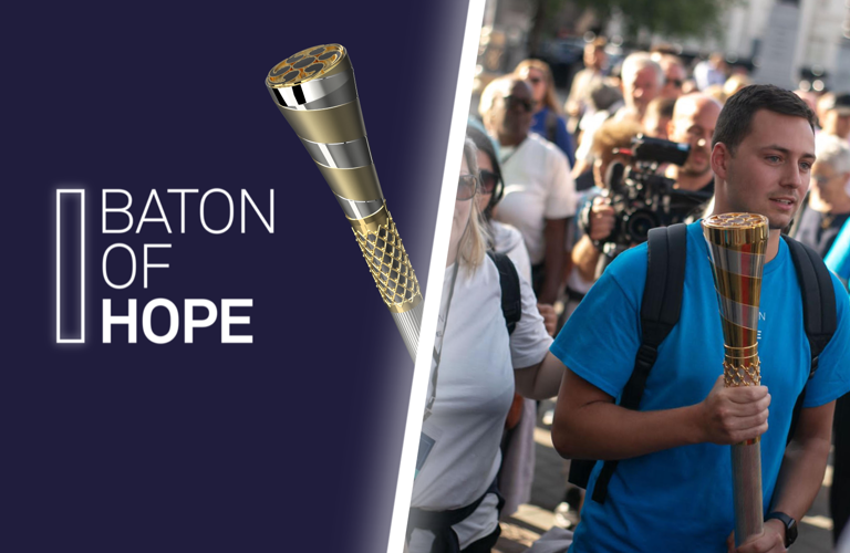 A composite image, split in half. One side shows the Baton of Hope logo in white on a purple background. The right side is a photograph of a man wearing a blue t-shirt holding the baton of hope in a calm crowd of people.