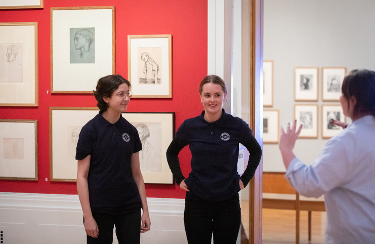 Two young people in Graves Gallery, listening to a member of Sheffield Museums staff.