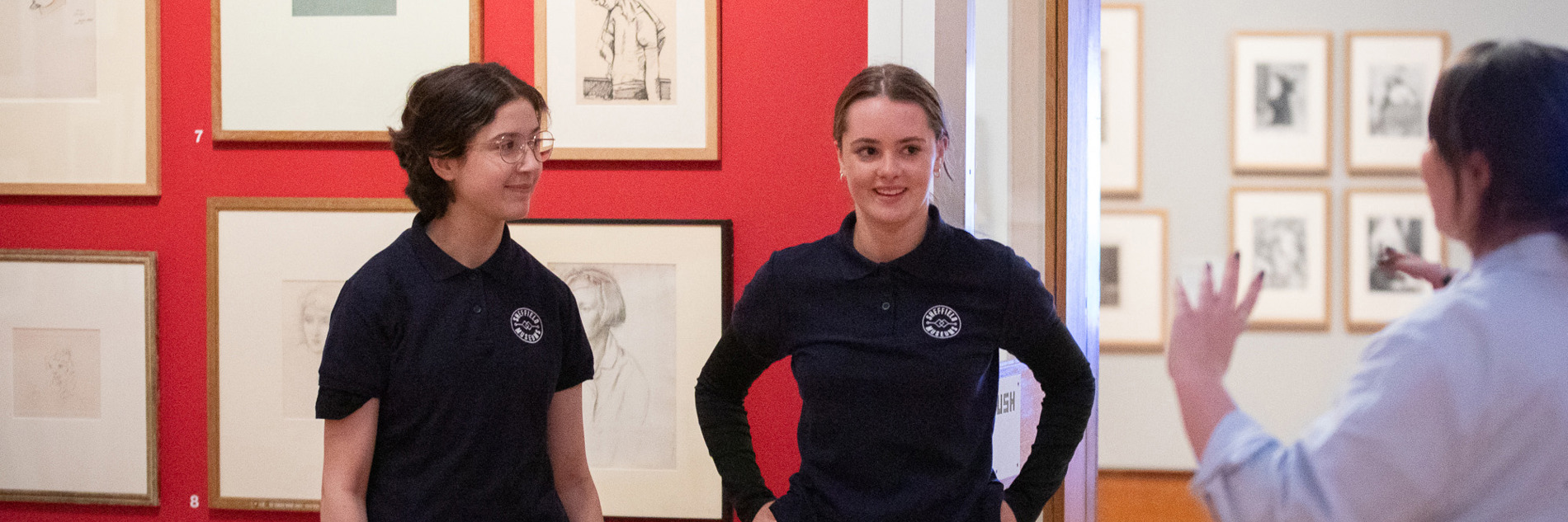 Two young people in Graves Gallery, listening to a member of Sheffield Museums staff.